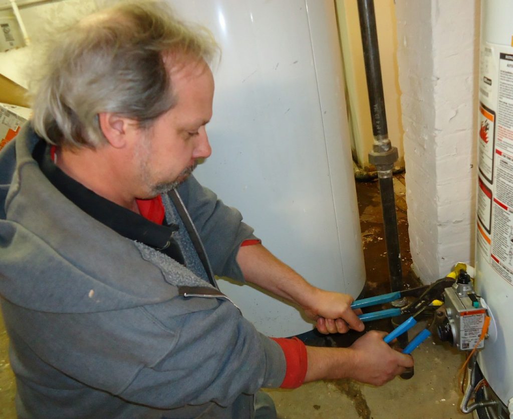 A plumber man fixing a big boiler. Boiler repair Dublin